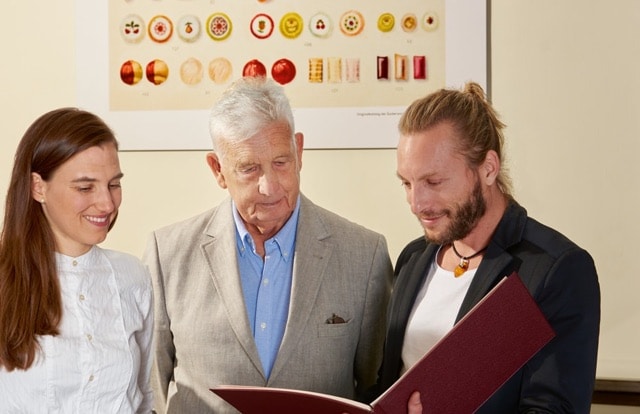 Friedrich W. Heller blättert gemeinsam mit den Zuckerlmachern der Zuckerlwerkstatt Christian Mayer und Maria Scholz im Katalog der Firma Heller