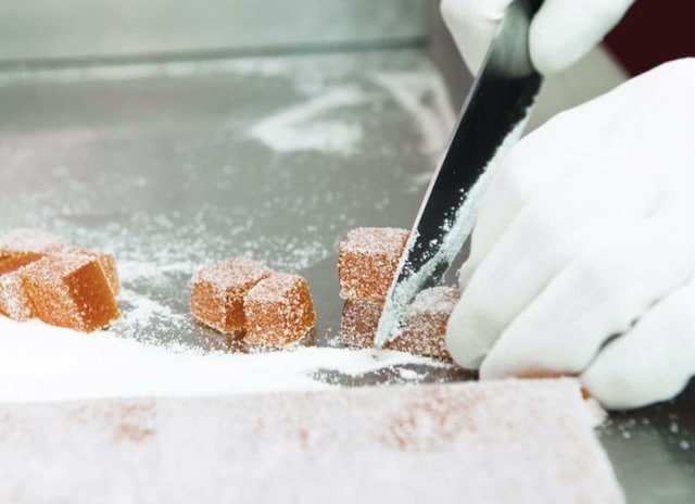 Fruchtgelees werden in der Zuckerlwerkstatt per Hand in kleine Würfel geschnitten