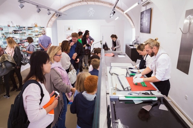 Kunden schauen dabei zu, wie die Bonbons live in der Schaumanufaktur der Zuckerlwerkstatt in Salzburg produziert werden