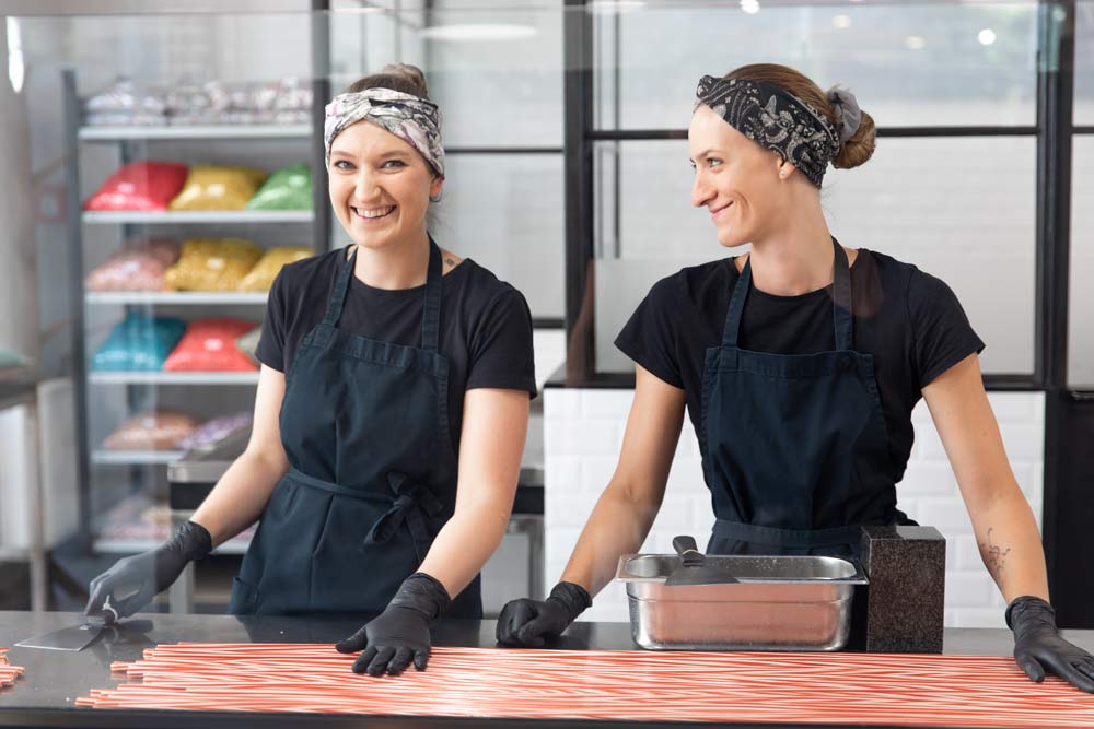 Lachende Mitarbeiter in der Zuckerlwerkstatt